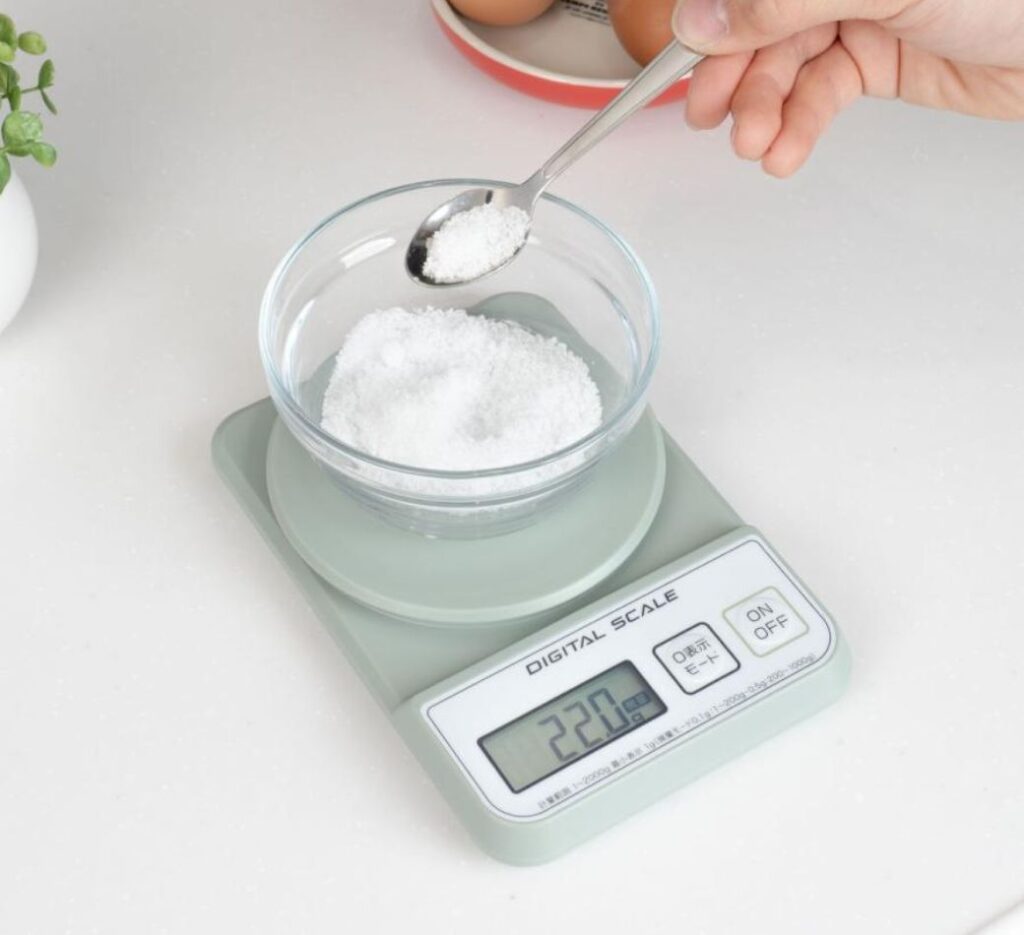 Weighing salt on a digital kitchen scale for a homemade electrolyte drink recipe
